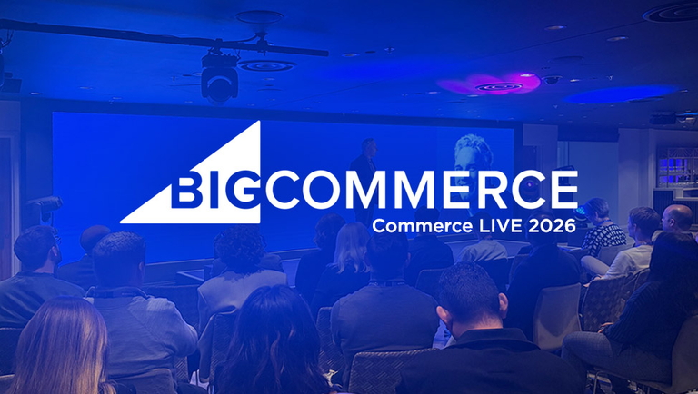 Publikum sitzt in einem Konferenzraum vor Bühne mit großem BigCommerce-Logo und Präsentation.