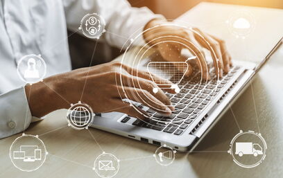 Person tippt auf einem Laptop