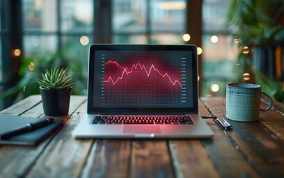 Laptop mit fallenden Diagramm auf Schreibtisch – Symbol für sinkende Impressionen in der Google Search Console